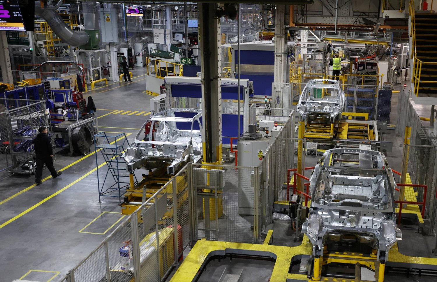 موظفون يعملون على خط الإنتاج في مصنع «هالوود» التابع لشركة «جاكوار لاند روفر» في ليفربول ببريطانيا (رويترز)