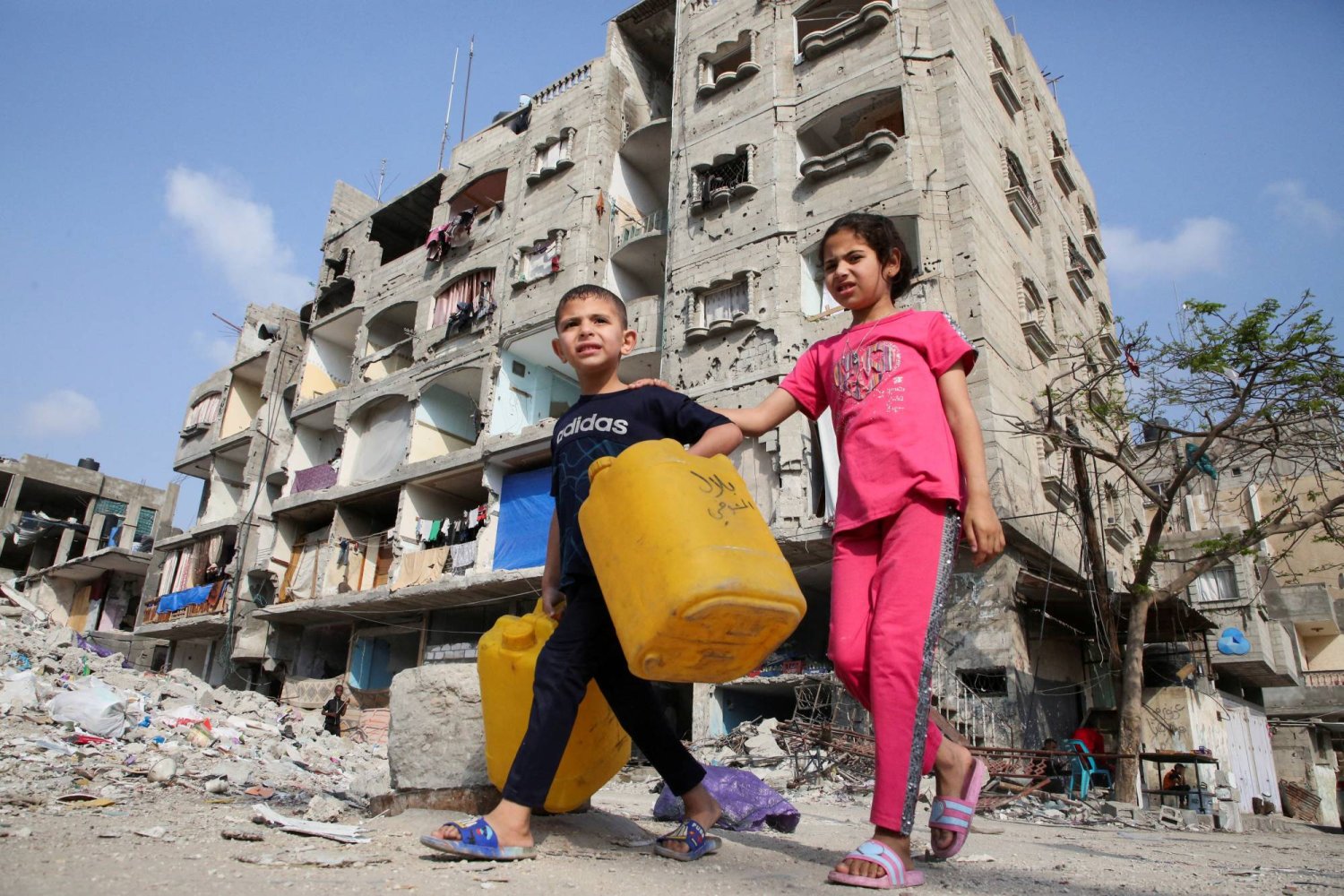 أطفال فلسطينيون يسيرون أمام منزل تضرر في غارة إسرائيلية برفح جنوب قطاع غزة (رويترز)