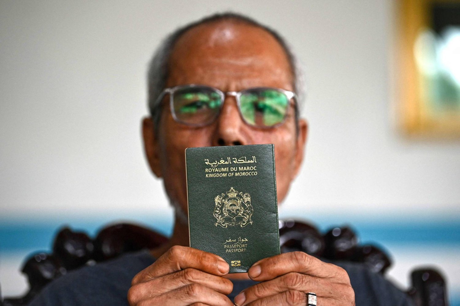 لي توان بِينه يحمل جواز سفره المغربي (أ.ف.ب)