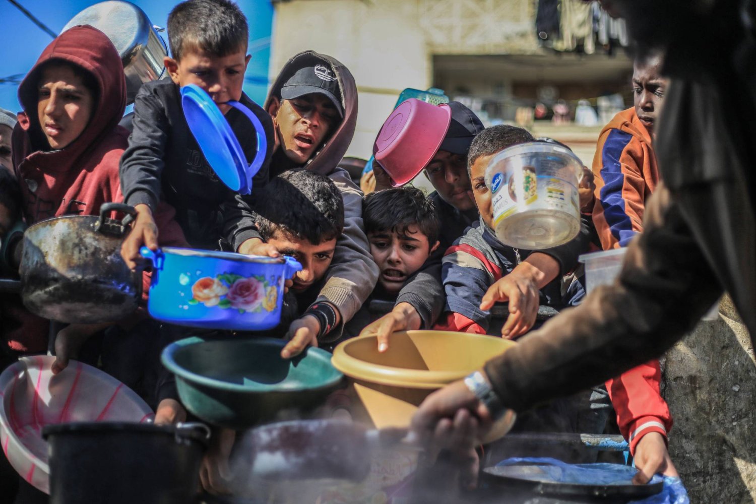 أطفال فلسطينيون ينتظرون للحصول على طعام تم إعداده في مطبخ خيري (د.ب.أ)