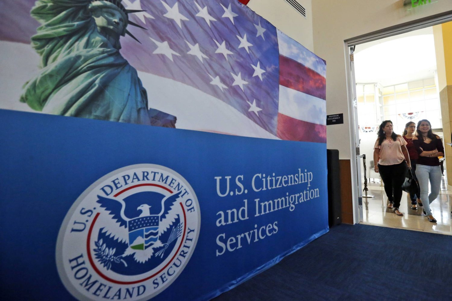 أشخاص يدخلون إلى مكتب خدمات المواطنة والهجرة الأميركية في ميامي (أ.ب)