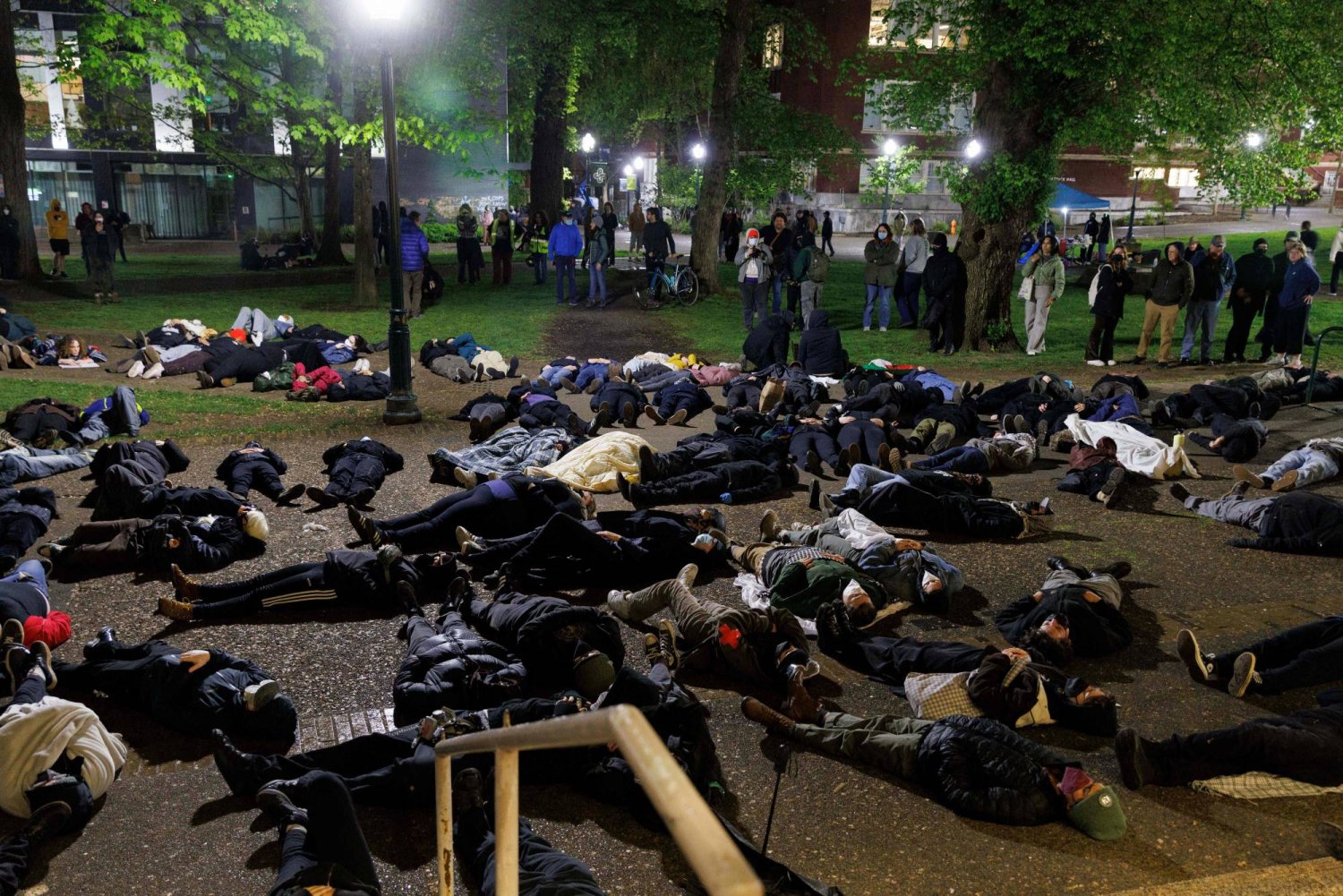 طلاب مؤيدون للفلسطينيين يستلقون على الأرض أثناء تظاهرهم في حرم جامعة ولاية بورتلاند في أوريغون (أ.ف.ب)