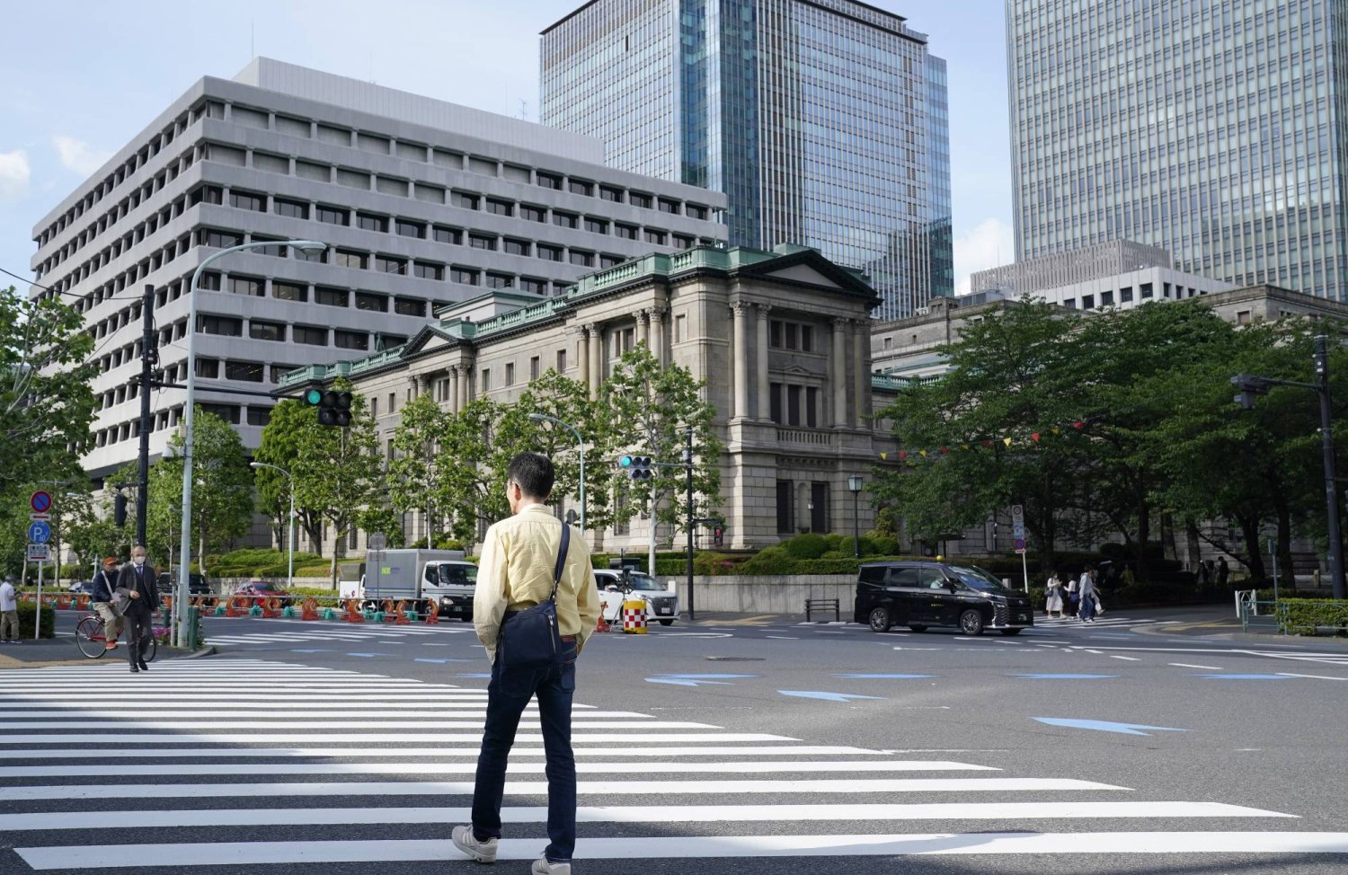 رجل يمر في شارع أمام مقر بنك اليابان وسط العاصمة طوكيو (إ.ب.أ)