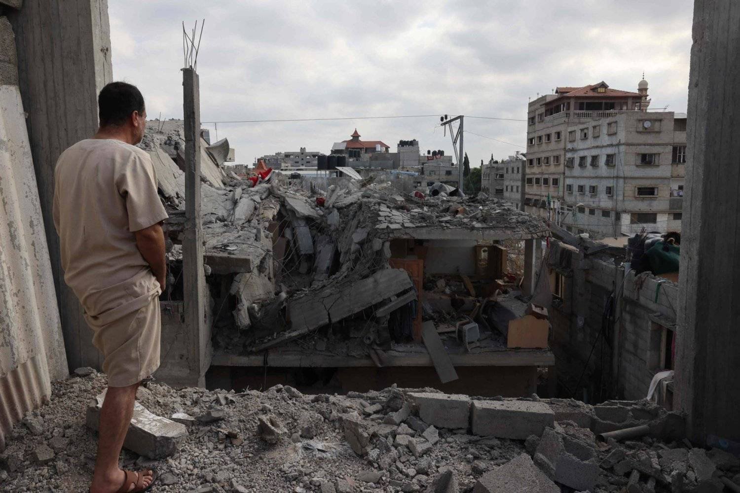 فلسطيني يعاين دماراً طال مباني في رفح (أقصى جنوب غزة) بعد غارة إسرائيلية سابقة (أ.ف.ب)