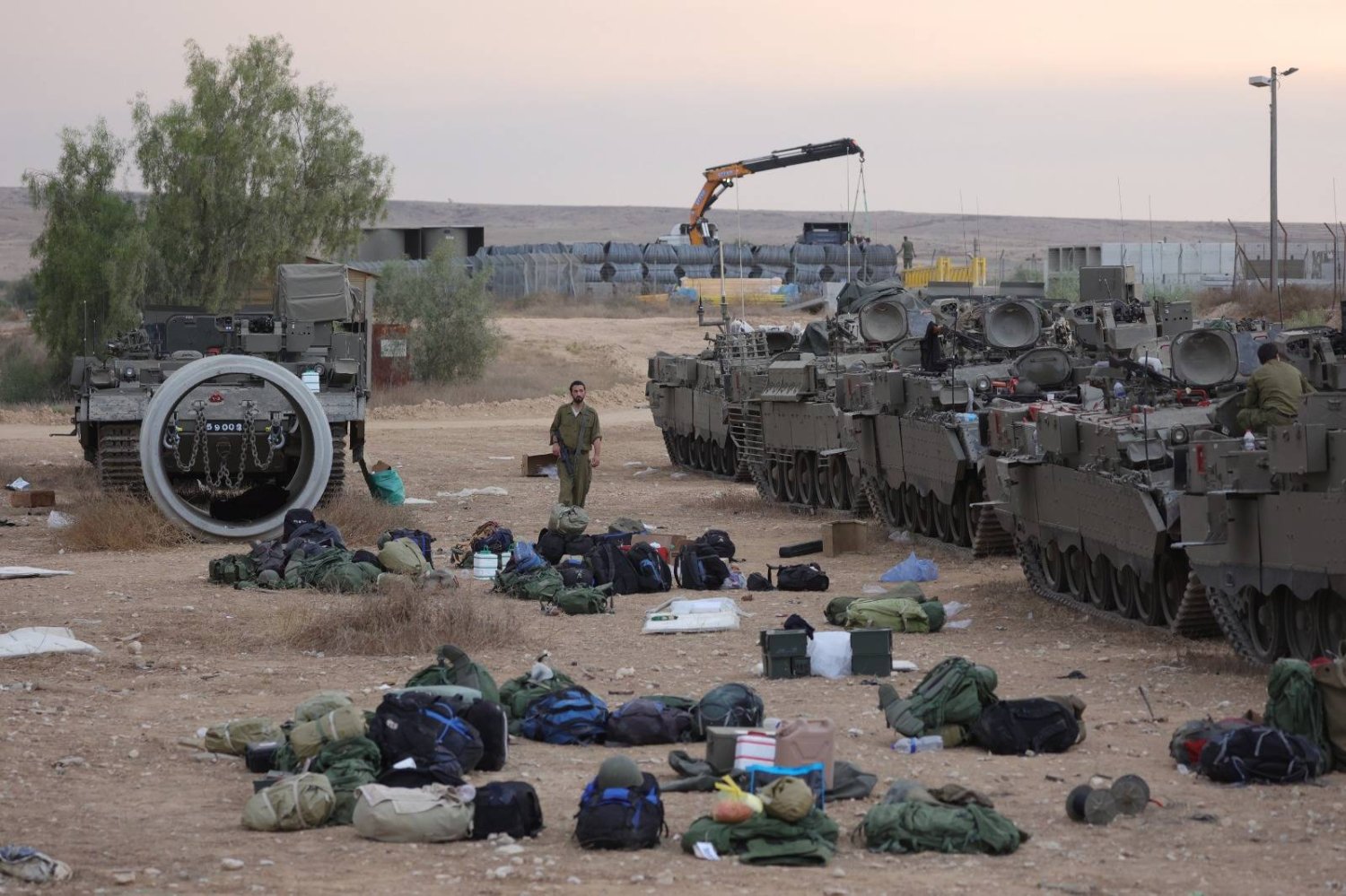 جنود احتياط إسرائيليون يستعدون بجوار ناقلات جنود مدرعة في معسكر للجيش بالقرب من بئر السبع (أرشيفية - إ.ب.أ)
