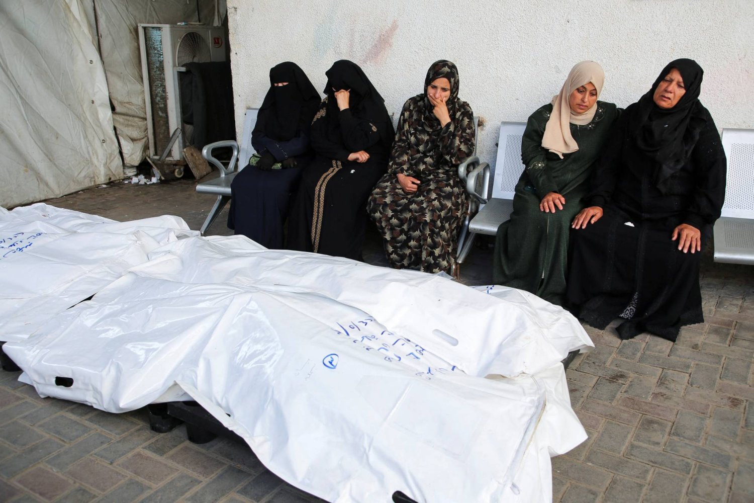 سيدات بجوار جثث أقارب لهن قتلوا بغارة إسرائيلية في مستشفى أبو يوسف النجار في رفح (رويترز)