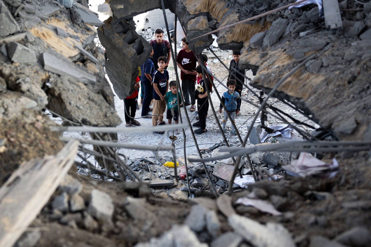 فلسطينيون يتفقدون أضرار القصف الإسرائيلي على رفح في جنوب قطاع غزة اليوم (أ.ف.ب)