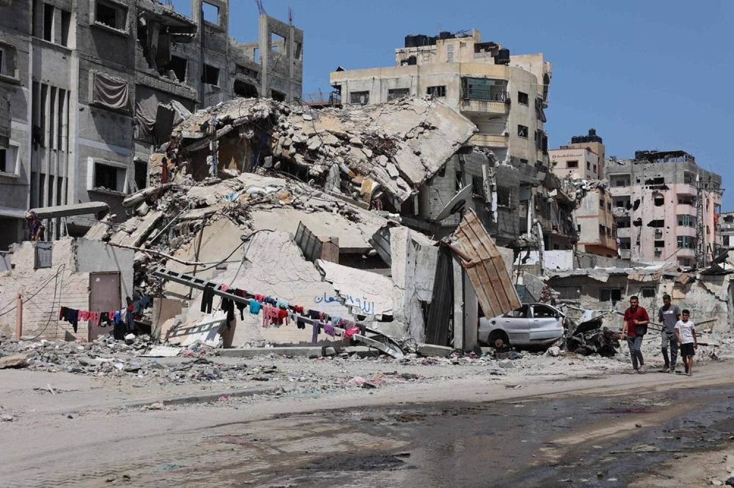  Palestinians walk a building destroyed by Israeli bombardment in Gaza City on May 3, 2024, amid the ongoing conflict between Israel and the Hamas movement. (AFP) 