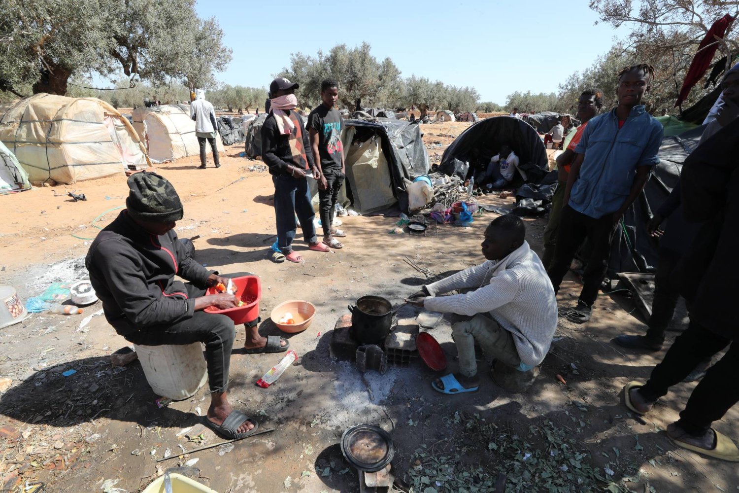 مهاجرون من دول أفريقيا جنوب الصحراء بأحد المخيمات التي أقاموها خارج صفاقس (إ.ب.أ)