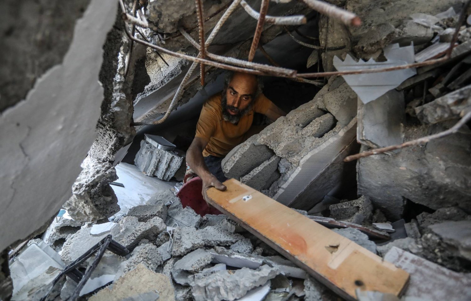 رجل فلسطيني يبحث داخل منزل مدمر إثر القصف الإسرائيلي على خان يونس (د.ب.أ)