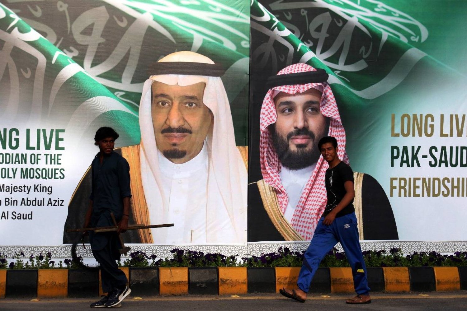 أحد شوارع باكستان وتظهر صورة خادم الحرمين الشريفين وولي العهد السعودي (إي.بي.آي)