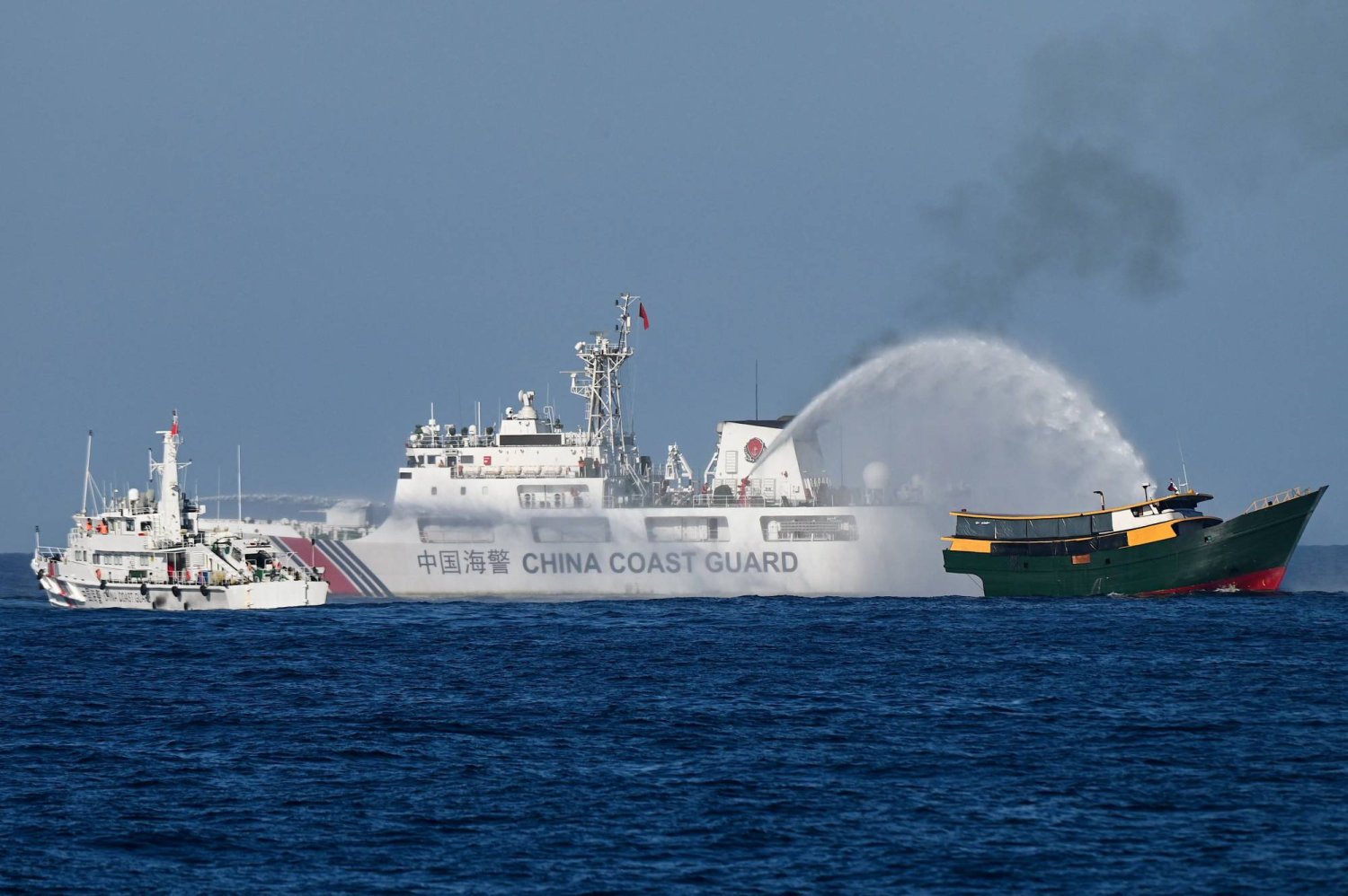 سفن خفر السواحل الصينية وهي توجه خراطيم المياه تجاه مركب تابع للجيش الفنزويلى في المياه المتنازع عليها ببحر الصين الجنوبي (أ.ف.ب)