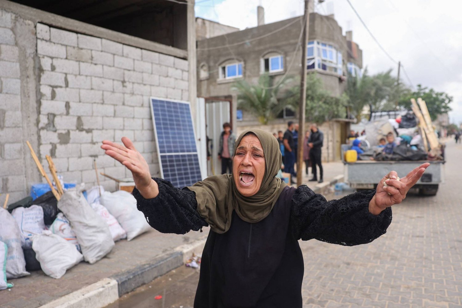 سيدة فلسطينية تصرخ بينما يجمع النازحون أغراضهم لمغادرة مناطق في شرق رفح جنوب قطاع غزة (أ.ف.ب)
