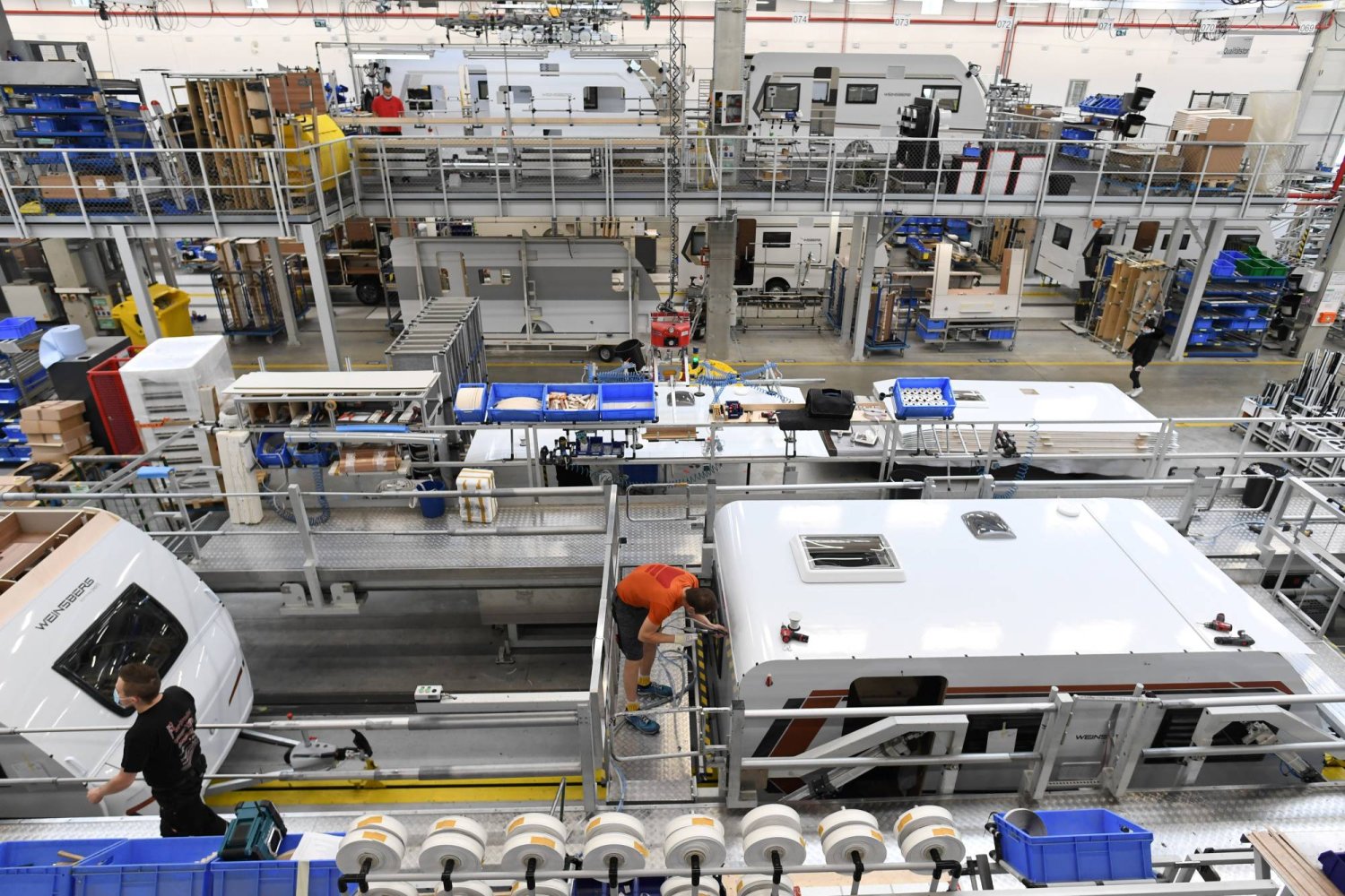 عمال يجمعون مواد التعبئة والتغليف في مصنع الشركة المصنّعة للكرفانات والمقطورات الألمانية في مقرها الرئيسي بالقرب من باساو (رويترز)
