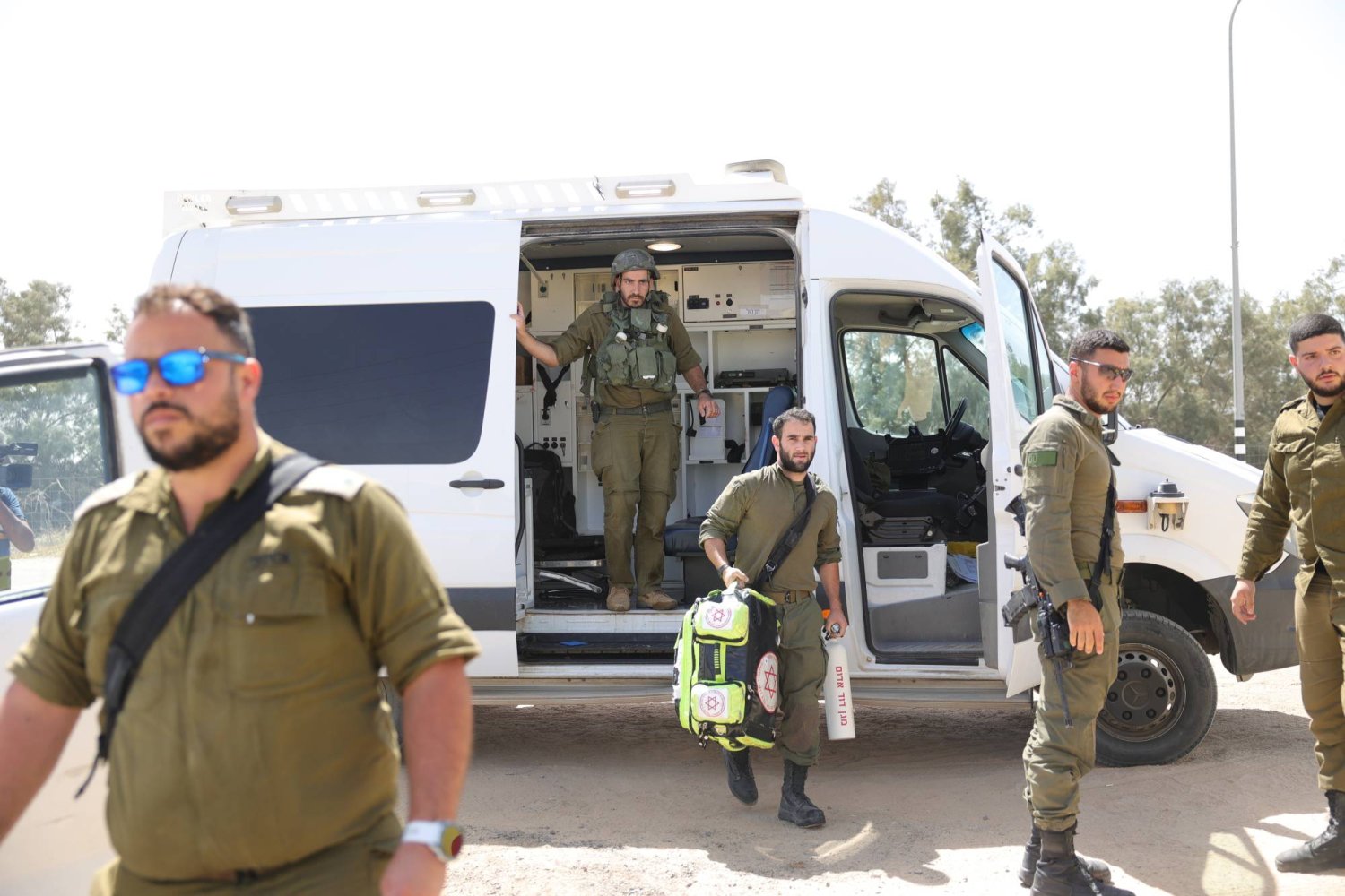 جنود ومسعفون إسرائيليون يتجمعون بالقرب من معبر كرم أبو سالم (إ.ب.أ)