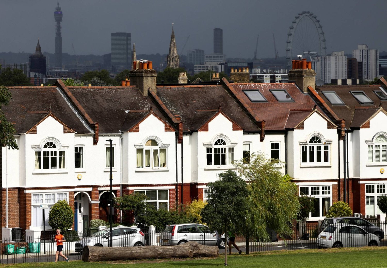 شخص يجري أمام صف من المساكن في جنوب لندن ببريطانيا (رويترز)