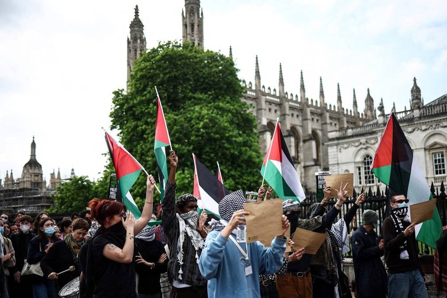 Students wave Palestinian flags as they march towards the Old School buildings to hand letters with their demands to the College Secretary during a protest in support of Palestinian people at Cambridge University, in Cambridge, eastern England on May 7, 2024. (AFP) 