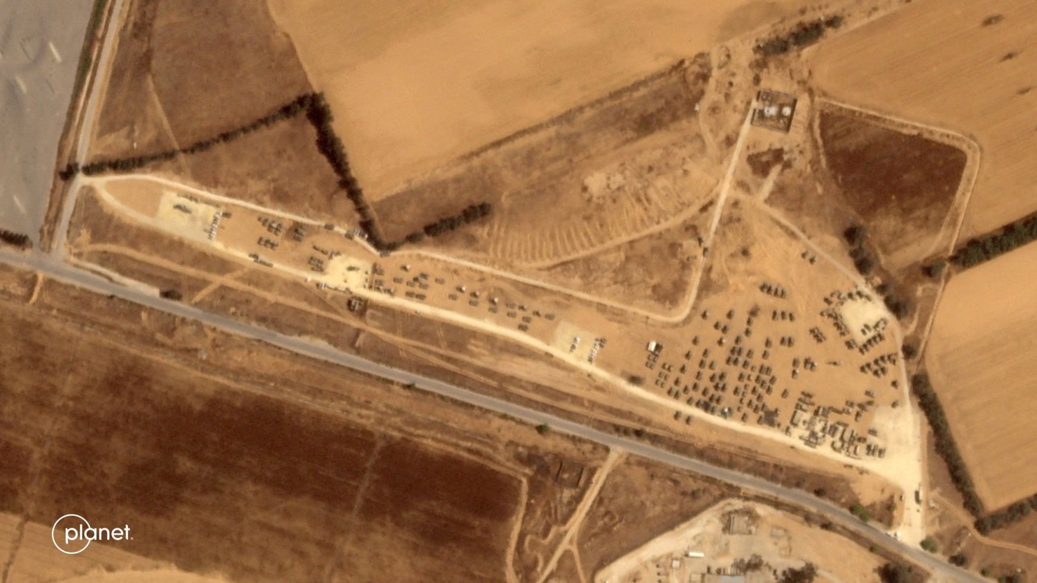 صورة بالأقمار الصناعية تظهر مركبات عسكرية إسرائيلية تتجمع في منطقة بجنوب إسرائيل بالقرب من معبر كرم أبو سالم الحدودي مع قطاع غزة (ا.ف.ب)