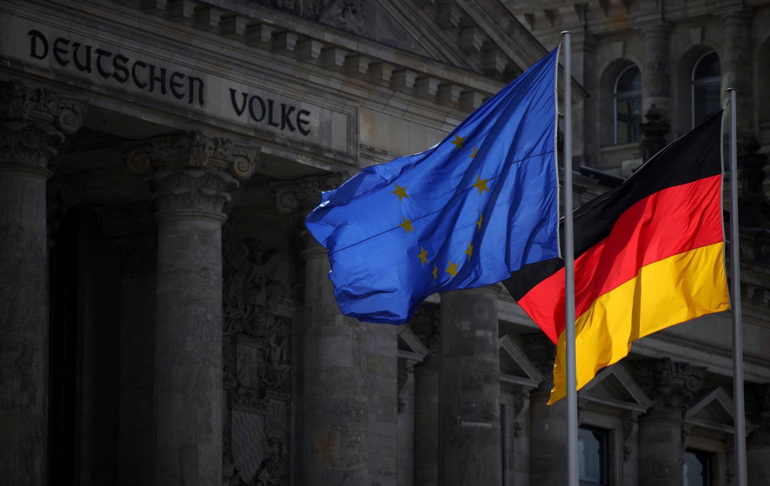 أعلام الاتحاد الأوروبي وألمانيا ترفرف أمام مبنى الرايخستاغ مقر مجلس النواب في البرلمان الألماني في برلين (رويترز)
