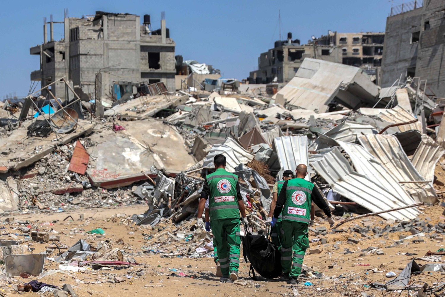 مسعفون فلسطينيون ينقلون جثث القتلى التي جرى اكتشافها بالقرب من مستشفى «الشفاء» في مدينة غزة منتصف الشهر الماضي (أ.ف.ب)