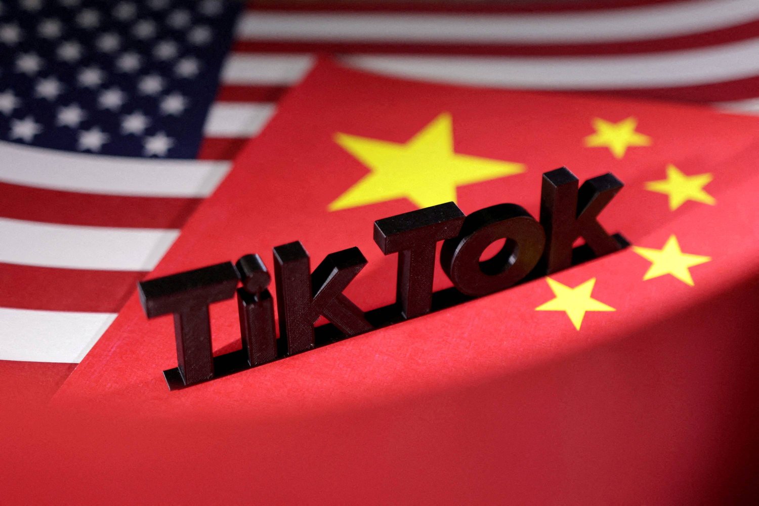 شعار «تيك توك» فوق علمَي أميركا والصين (رويترز)