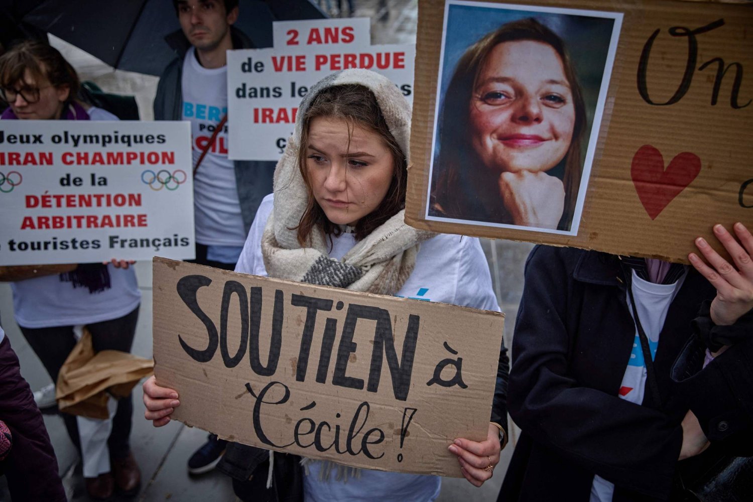 متظاهرة تحمل صورة الرهينة الفرنسية في إيران سيسيل كوهلر المعتقلة منذ عامين في 23 مارس الماضي (أ.ف.ب)