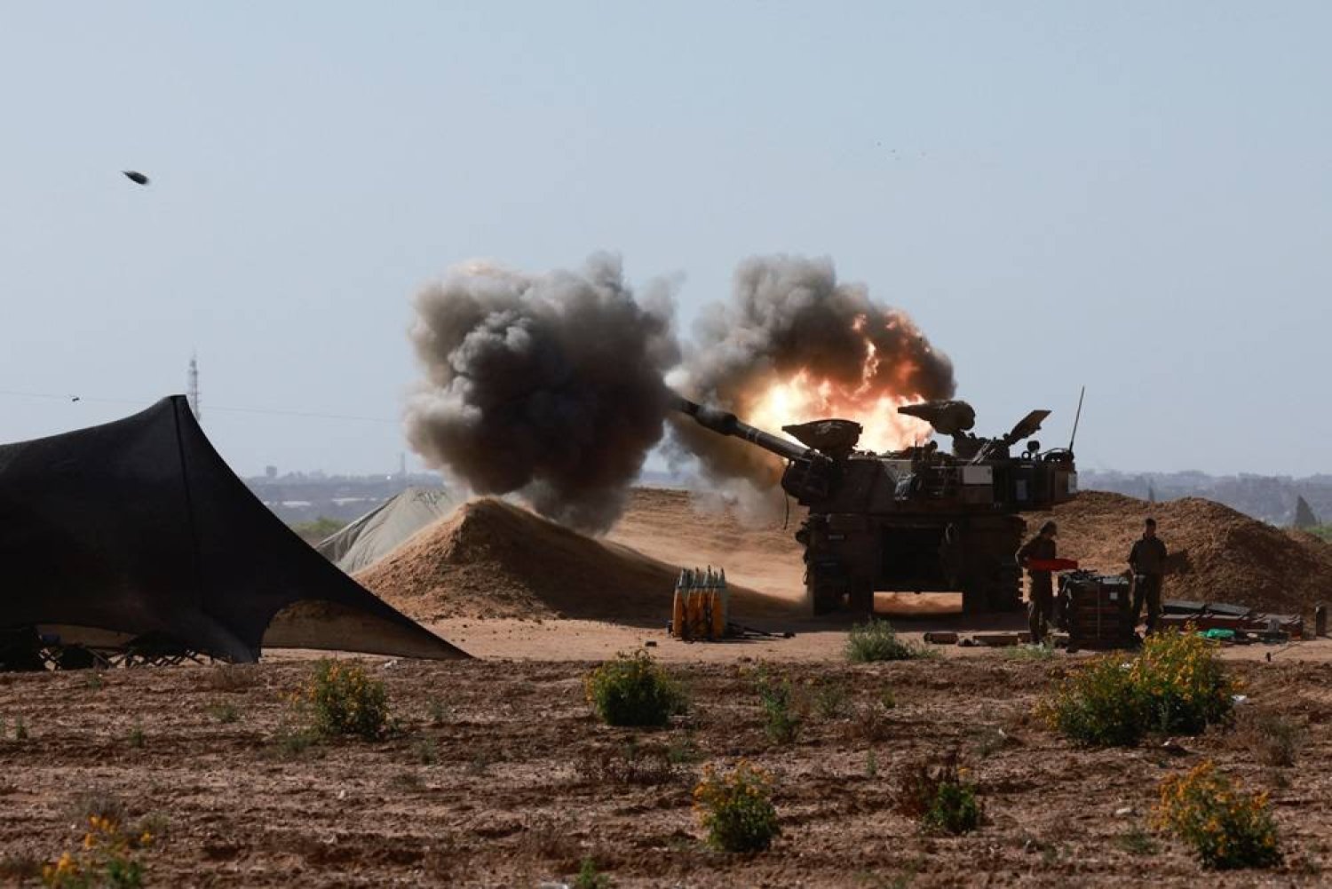  An Israeli military vehicle fires near the Israel-Gaza border, amid the ongoing conflict between Israel and the Palestinian group Hamas, in southern Israel, May 8, 2024. (Reuters)
