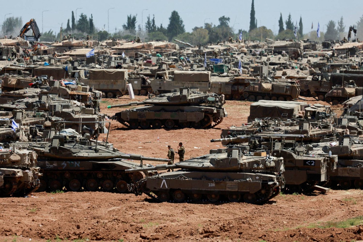 جنود إسرائيليون يسيرون بجوار مركبات عسكرية بالقرب من الحدود بين إسرائيل وغزة، وسط الصراع المستمر بين إسرائيل وحركة "حماس" في جنوب إسرائيل، 8 مايو 2024 (رويترز)