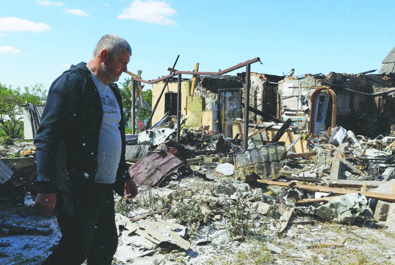 
أوكراني يسير بجانب منزل تعرّض للدمار بعد إطلاق صاروخي ليلي في قرية كراسيليفكا بالقرب من كييف (إ.ب.أ)