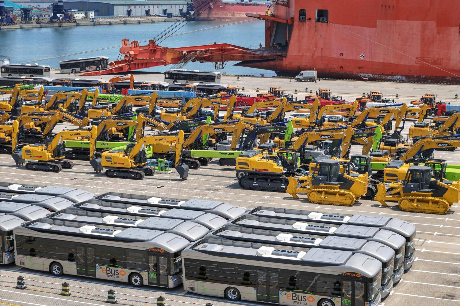 حافلات وحفارات جديدة للتصدير في انتظار تحميلها على سفينة في ميناء يانتاي في يانتاي بمقاطعة شاندونغ شرق الصين (أ.ف.ب)