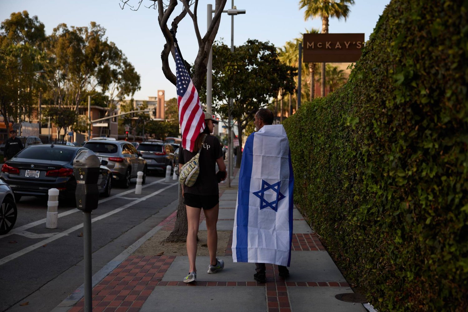 أشخاص يسيرون وهم يرتدون العلم الإسرائيلي ويحملون العلم الأميركي في مسيرة مؤيدة لإسرائيل خارج جامعة جنوب كاليفورنيا أمس (إ.ب.أ)