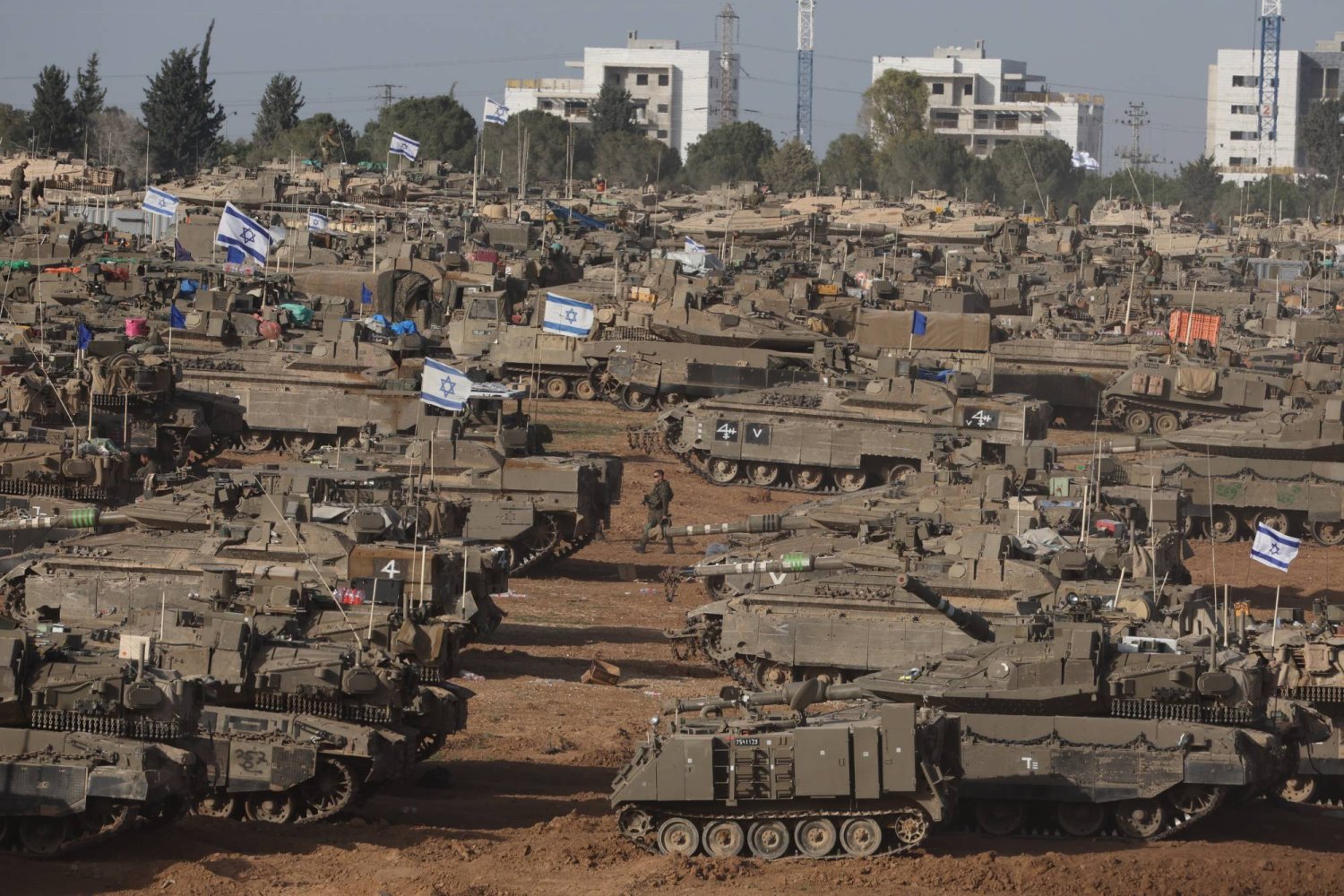مركبات عسكرية إسرائيلية تحتشد بالقرب من السياج الحدودي مع قطاع غزة (إ.ب.أ)
