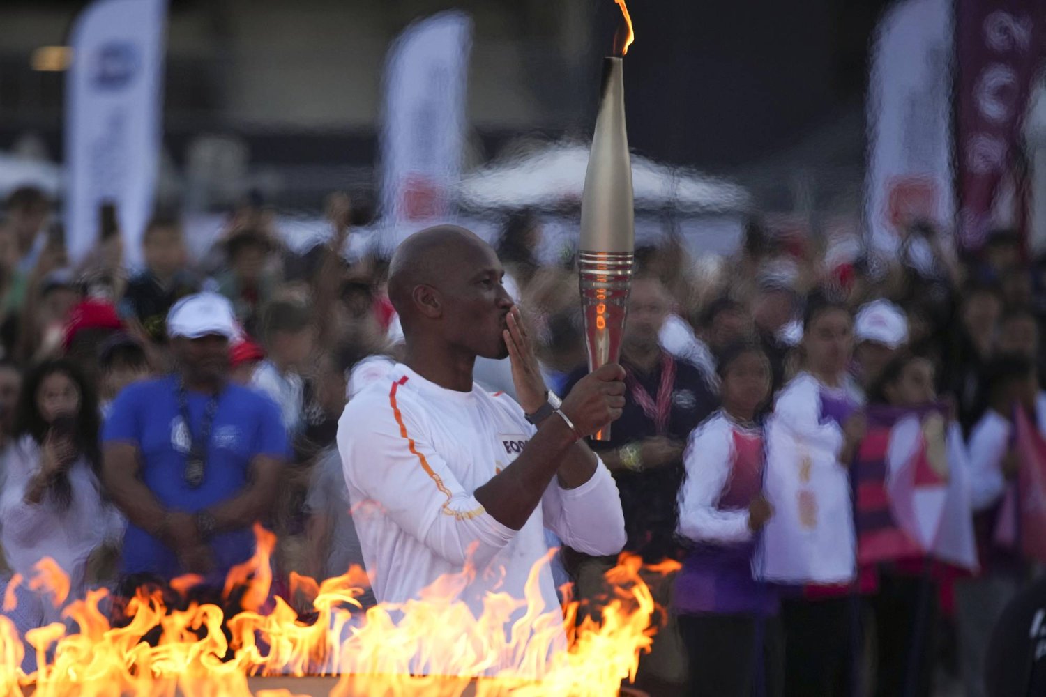 دروغبا لحظة حمله الشعلة الأولمبية في باريس (أ.ب)