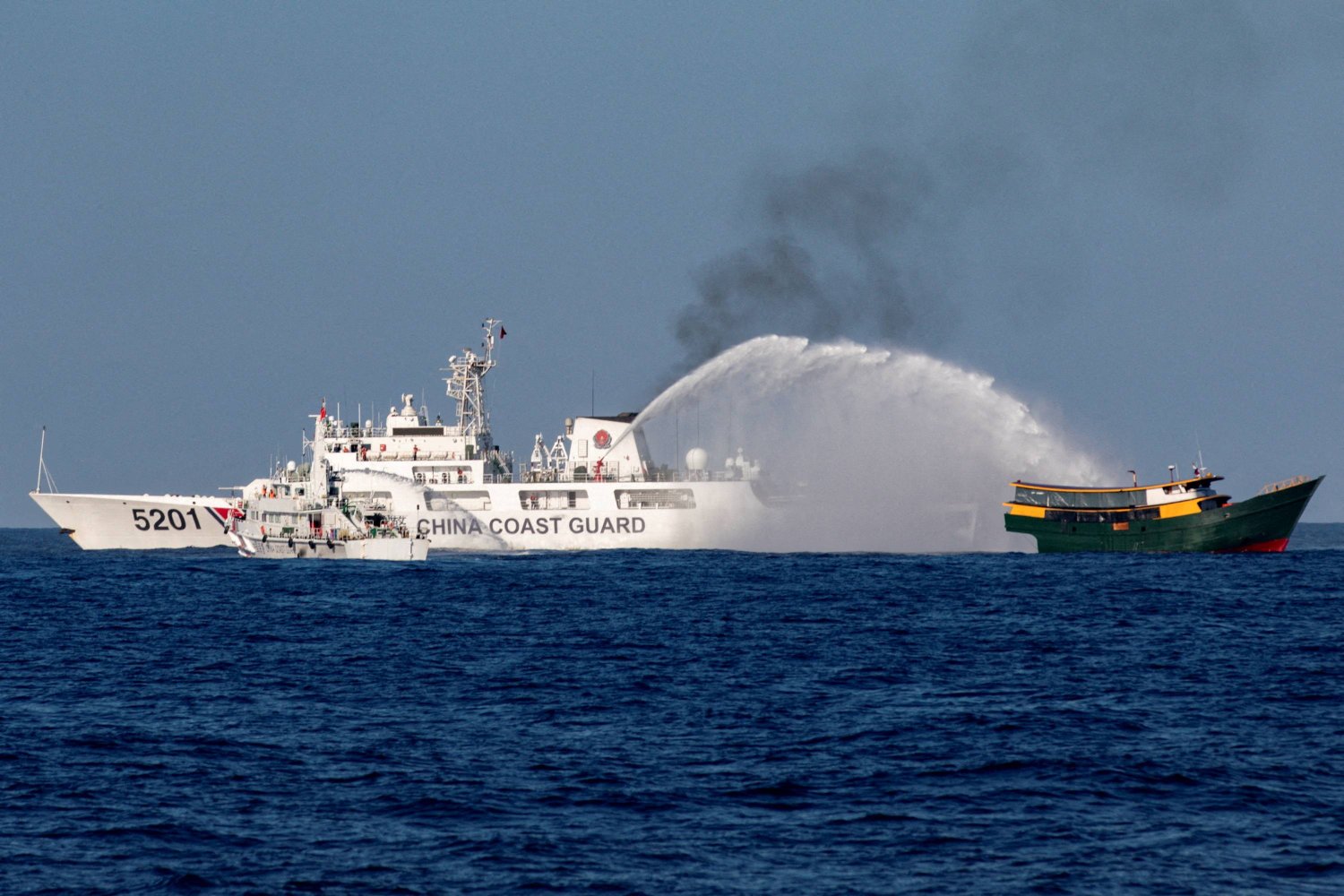 سفن خفر السواحل الصينية تطلق خراطيم المياه باتجاه سفينة إعادة الإمداد الفلبينية التي كانت في طريقها إلى بحر الصين الجنوبي (رويترز)