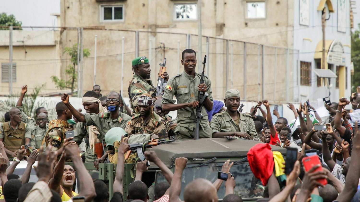 حشود تهتف أثناء عرض لجنود ماليين في شوارع باماكو عاصمة مالي، في أغسطس 2020 (أ.ف.ب)