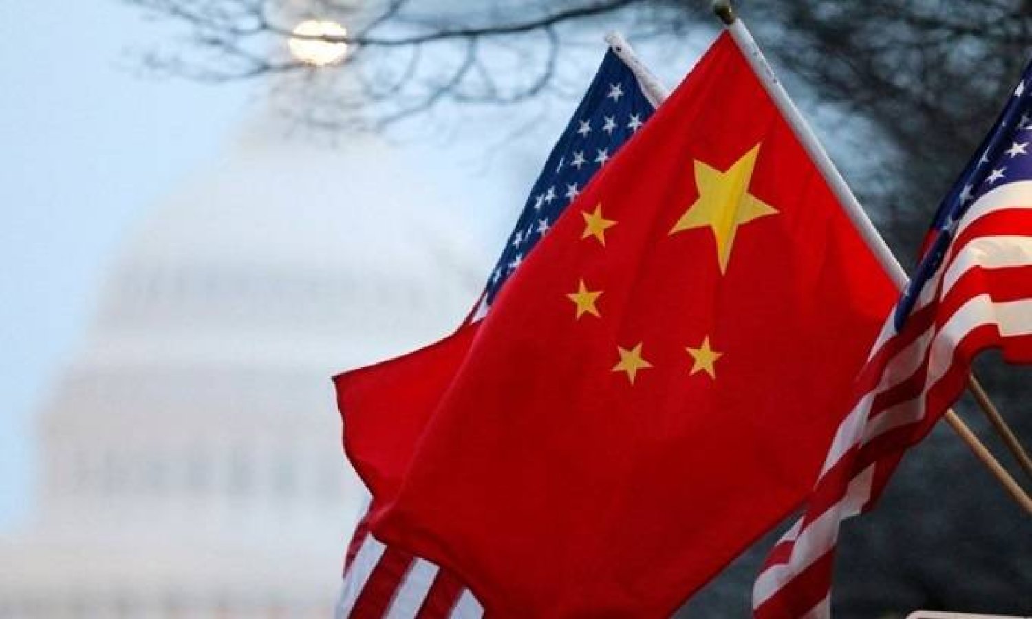 علما الصين والولايات المتحدة وفي الخلفية مبنى الكابيتول الأميركي (رويترز)
