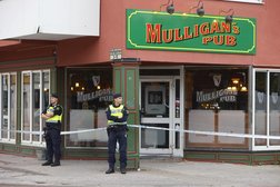 شرطيان سويديان خارج حانة آيرلندية في ساندفيكن بالسويد بعد يوم من إطلاق نار أدى إلى مقتل شخصين وإصابة اثنين آخرين (أ.ف.ب)
