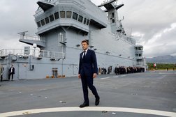 الرئيس الفرنسي إيمانويل ماكرون يسير على سطح حاملة الهليكوبتر «ديكسمود» (رويترز)