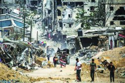 
فلسطينيون وسط الدمار الذي خلَّفته القوات الإسرائيلية في خان يونس جنوب قطاع غزة أمس (أ.ف.ب)