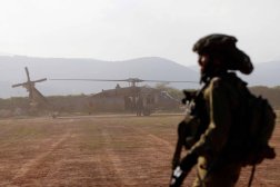 جندي إسرائيلي ينظر إلى طائرة هليكوبتر أثناء إقلاعها خلال تدريب عسكري في الجليل الأعلى بالقرب من الحدود اللبنانية (أ.ف.ب)