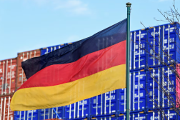 A German flag blows in the wind in front of a stack of containers at the harbour in Hamburg, Germany, February 24, 2022. REUTERS/Fabian Bimmer/File Photo Purchase Licensing Rights