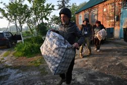 متطوعون أوكرانيون يساعدون سكاناً محليين على إخلاء بيوتهم في مناطق تقع شمال مدينة خاركيف (أ.ف.ب)