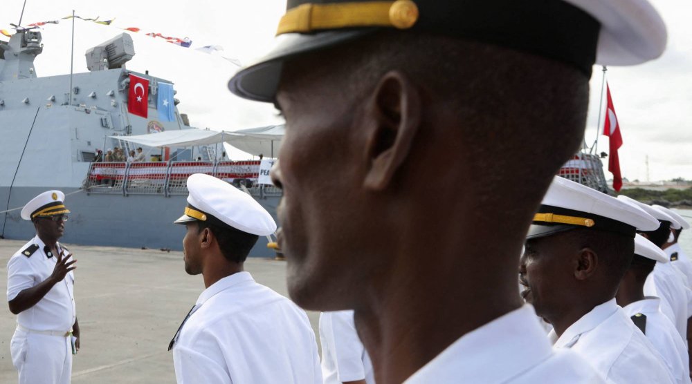 قوات عسكرية صومالية تقف بالقرب من سفينة البحرية التركية التي رست في ميناء مقديشو بعد توقيع اتفاقية دفاعية واقتصادية بين الصومال وتركيا في مقديشو الثلاثاء (رويترز)