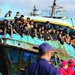 مهاجرون على متن قارب متهالك رسا في ميناء بجزيرة كريت (أ.ب)