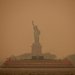 تمثال الحرية يحيطه الضباب والدخان الناجم عن حرائق الغابات في كندا (رويترز)