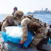 جنديان يحملان بعضاً من شحنة الأسلحة الإيرانية المصادرة في خليج عمان (البحرية البريطانية)