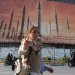 امرأة غير محجبة تمر أمام لافتة دعائية للصواريخ الإيرانية في ساحة «ولي عصر» وسط طهران الاثنين الماضي (رويترز)