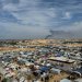 مخيم للنازحين برفح جنوب غزة وفي الخلفية يتصاعد الدخان بمدينة خان يونس (رويترز)